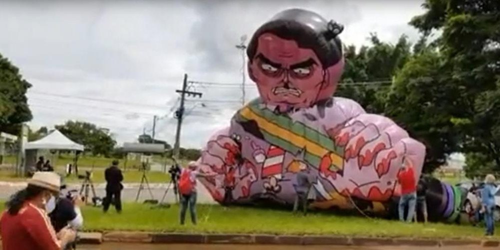 Manifestantes inflam boneco de Bolsonaro sujo de sangue em frente à Anvisa